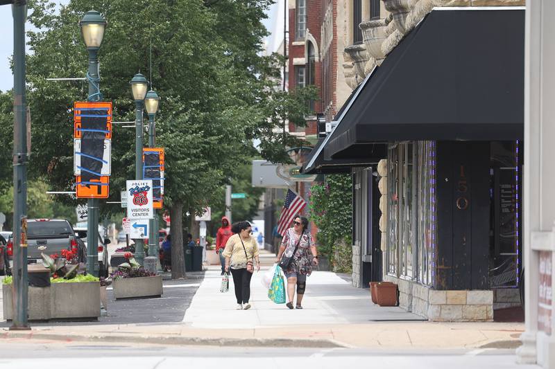 A couple walks along North Chicago Street in downtown Joliet on Monday July 8, 2024.