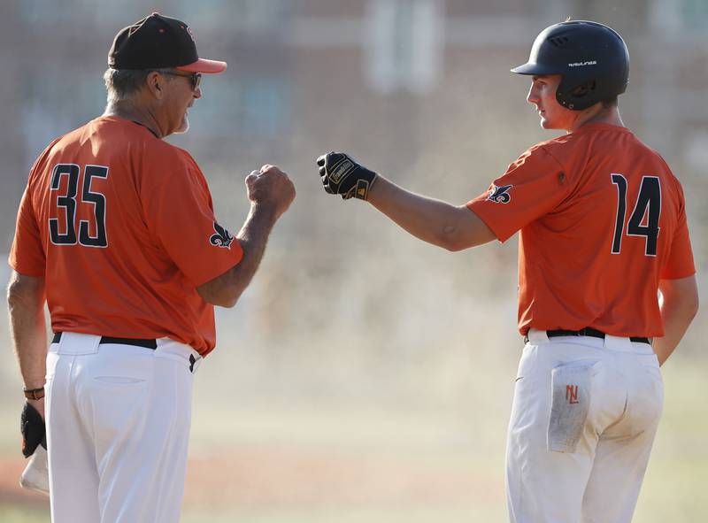 St. Charles East's Mac Paul (14) is congratulated by assistant coach Doug Sutor after getting a hit during the Class 4A York regional semi-final between Wheaton Warrenville South and St. Charles East in Elmhurst on Thursday, May 23, 2024.