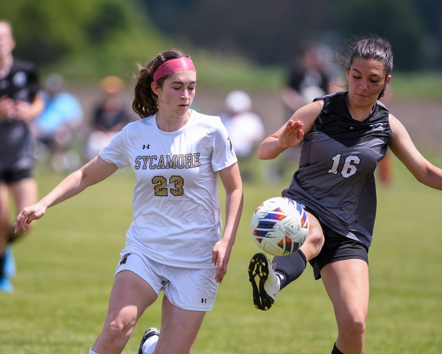 Kaneland's Alex Warrington (16) kicks the ball while being defended by Sycamore's Hannah Raetzke (23) during the regional title game on Saturday May 18, 2024, held at Kaneland High School.
