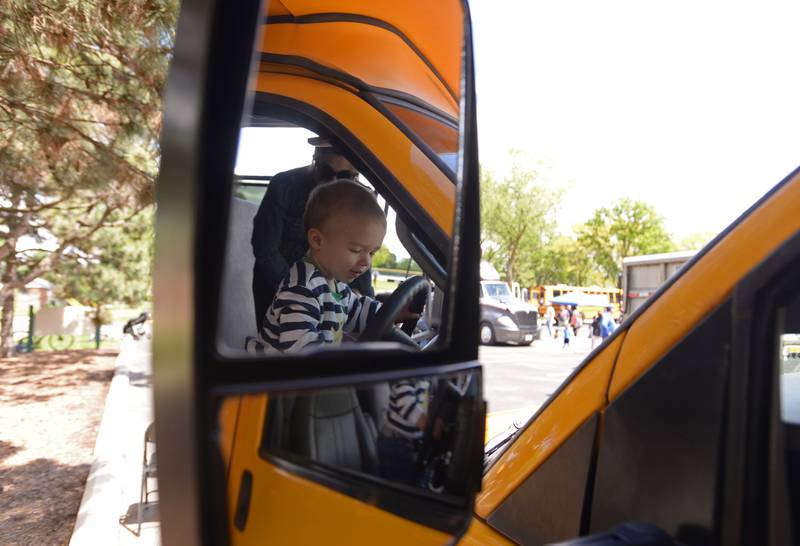 Children including Jude Swoboda of La Grange get behind the wheel of a small school bus during the La Grange Park District's Touch A Truck event held at Sedgwick Park Saturday May 11, 2024.