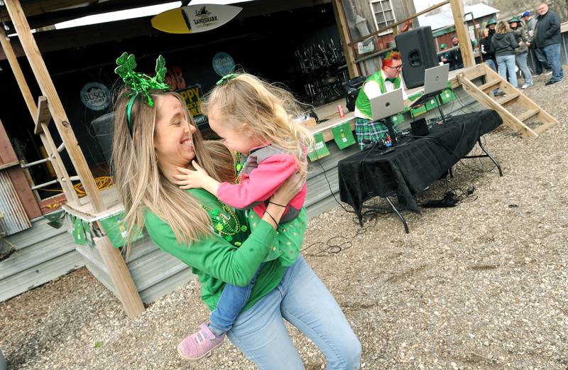 Three-year-old Reagan Fisher dances with her mom Heather at the Southbank Original Barbecue after the Yorkville St. Patrick's Day parade on Hydraulic Avenue, Saturday, Mar. 16, 2024.