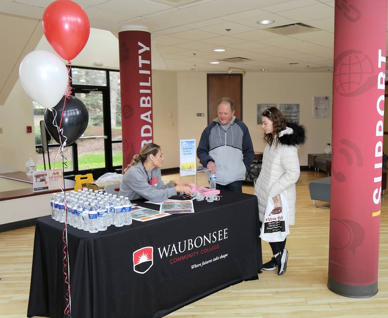 Marketing Manager Amanda Gregolunas answers questions from Jeff and Sopie Heidrich of Oswego at the Transfer and Career Open House at the Waubonsee Community College Sugar Grove Campus on April 20, 2024.