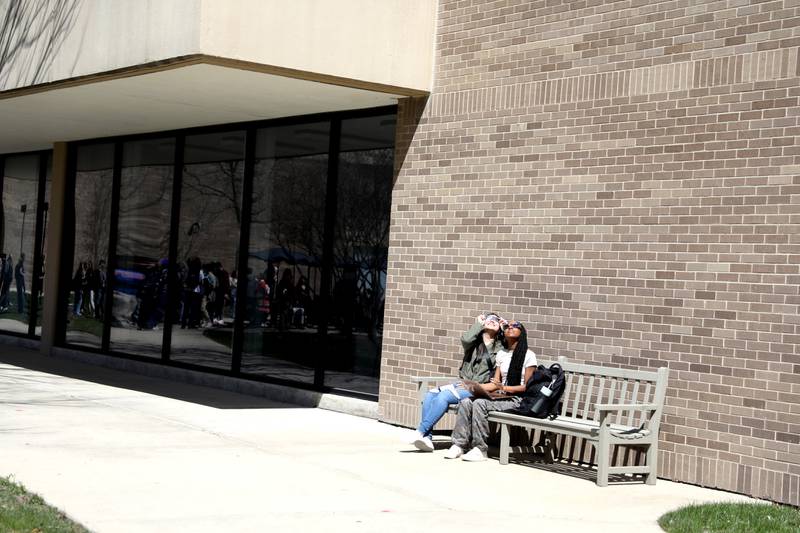 Waubonsee Community College students Mariah Luna (left) and Brenay Cooper (right) look at the sun using special protective glasses during the solar eclipse on Monday, April 8, 2024 at the college’s Sugar Grove campus.