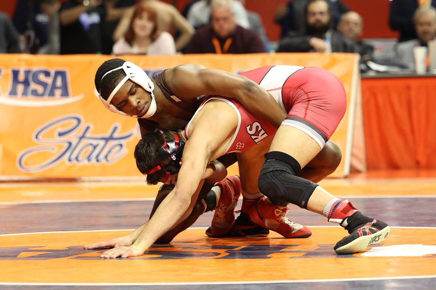 Joliet Catholic’s Jason Hampton works over Maine South’s Teddy Flores in the 120-pound Class 3A state championship match on Saturday, Feb. 17th, 2024 in Champaign.