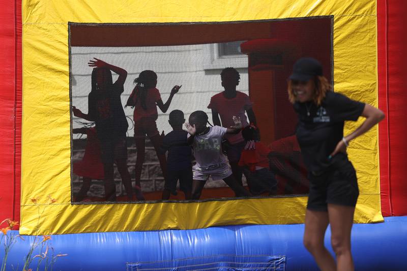 A group of kids play in the jump tent at the Healing the Hood event held at the St. Mark CME Church in Joliet on Saturday June 29, 2024.