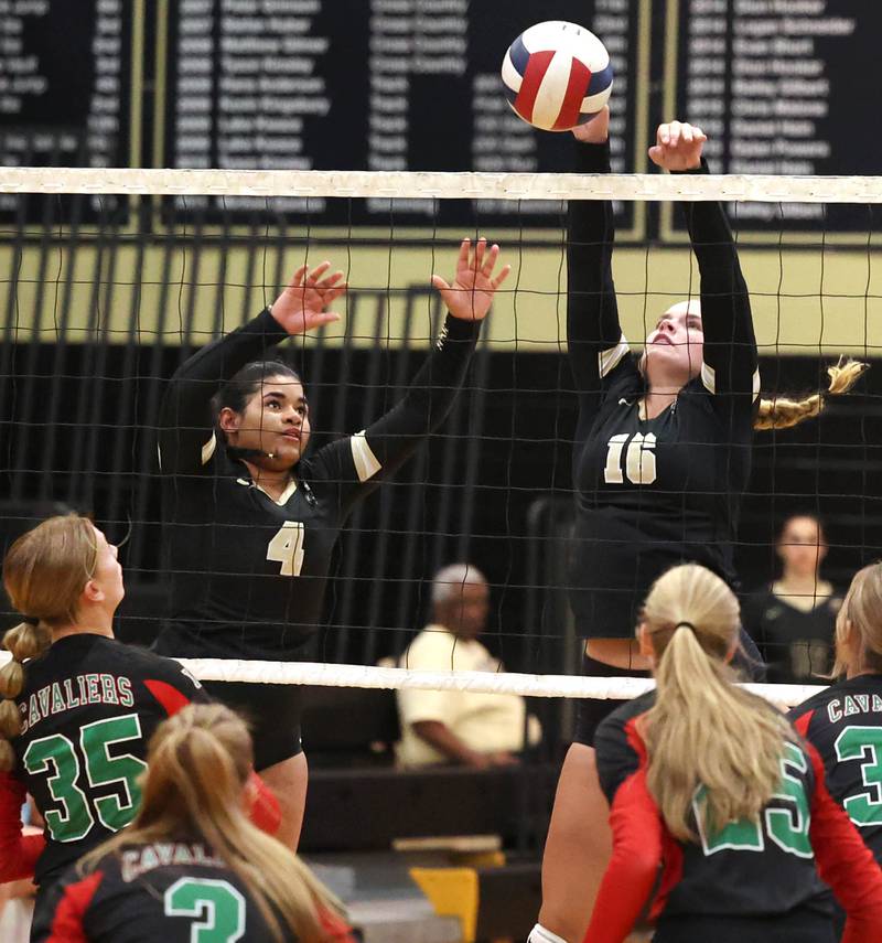 Sycamore's Hatie-Jane Alexander (left) and Jaycie Funderburg go up for a block during their match against LaSalle-Peru Tuesday, Oct. 10, 2023, at Sycamore High School.