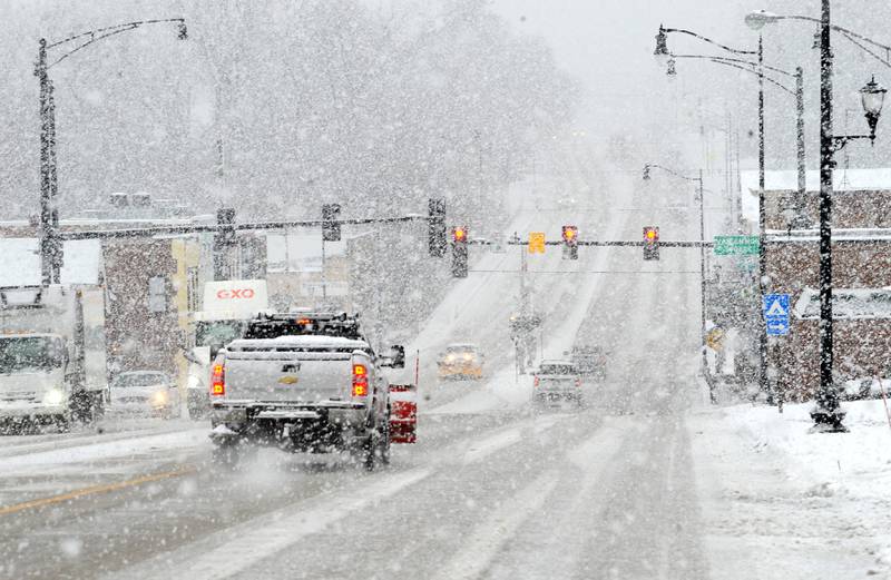 Traffic makes its way through downtown during a major snow storm in Yorkville on Tuesday, Jan. 9, 2023.