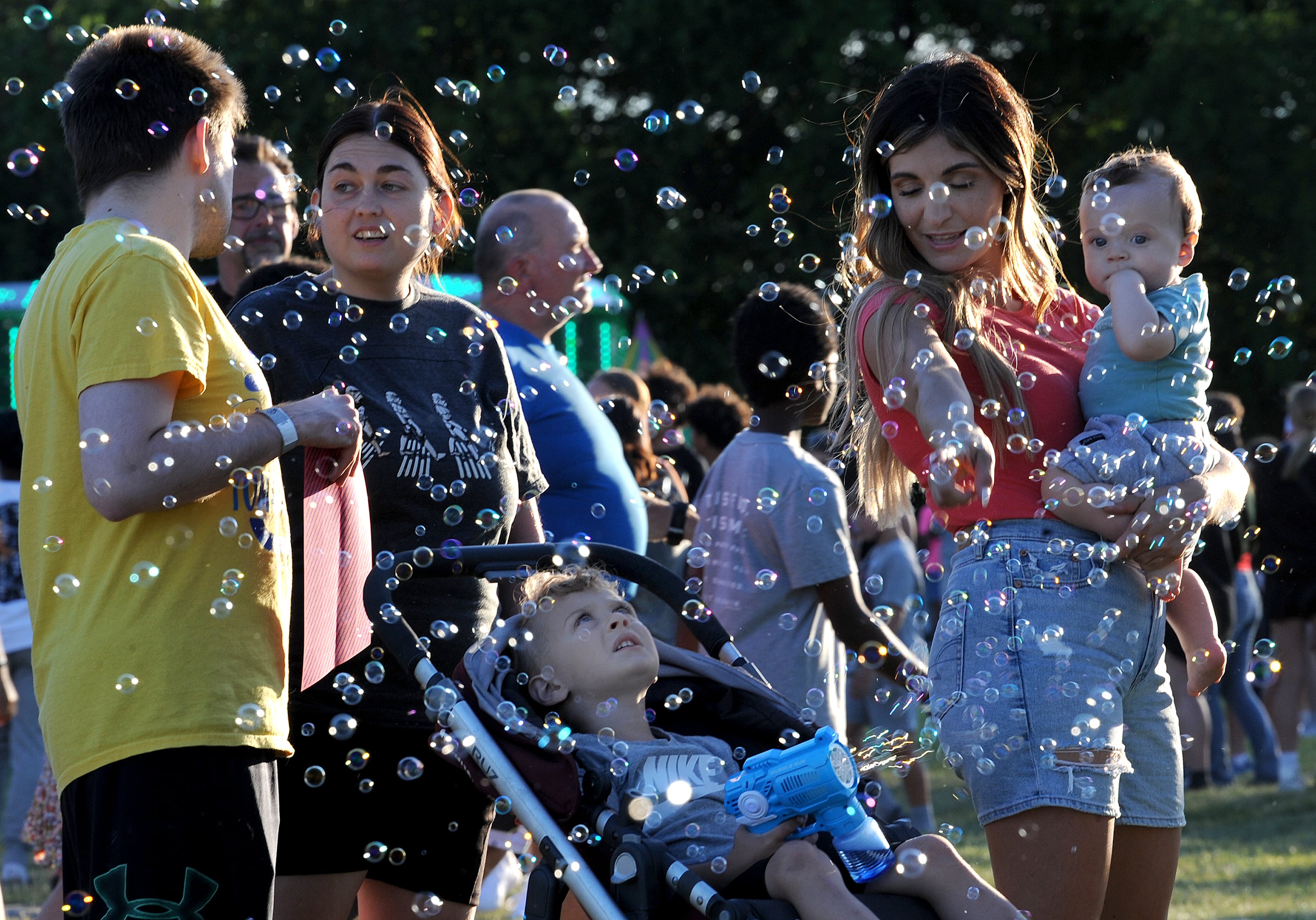 Three-year-old Dominic Robertson of Oswego envelopes his family in bubbles during the Oswegoland Park District's PrairieFest on Friday, June 14, 2024.