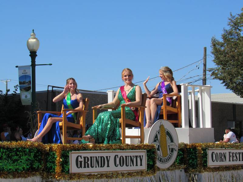 Grundy County Corn Festival Queen Tessa Brooks and runners-up Mayday Matthews and Macy Shell ride along Liberty Street.