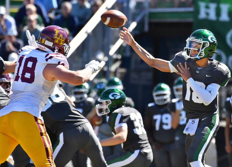 Glenbard West quarterback Oliver Valdez (right) fires a pass over Loyola's Tommy Ghislandi (18) during a game on September 7, 2024 at Glenbard West High School in Glen Ellyn.