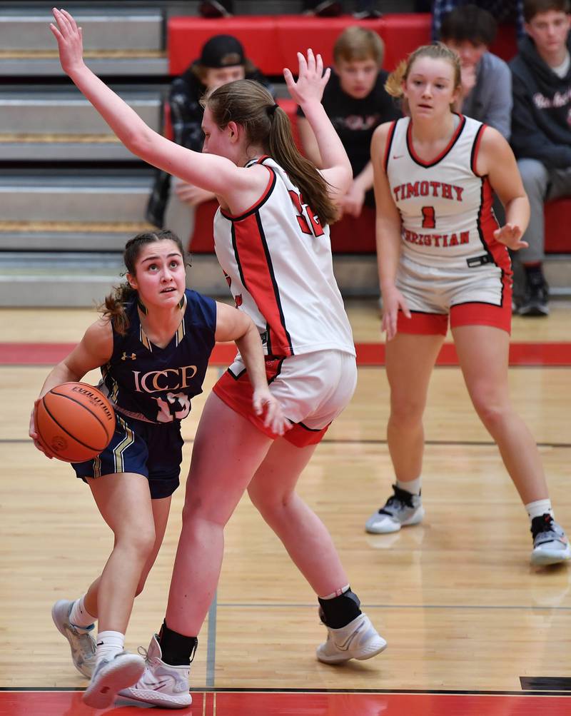 IC Catholic's Analisa Raffaelli (left) drives to the basket from under Timothy Christian's Grace Roland during the Class 2A Timothy Christian Regional championship game on Feb. 17, 2023 at Timothy Christian High School in Elmhurst.