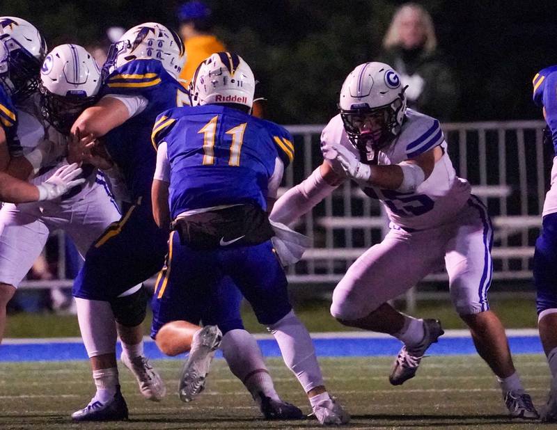 Geneva’s Charlie Winterhalter (15) shoots the gap to defend against carry by Wheaton North's Max Howser (11) during a football game at Wheaton North High School on Friday, Oct. 6, 2023.