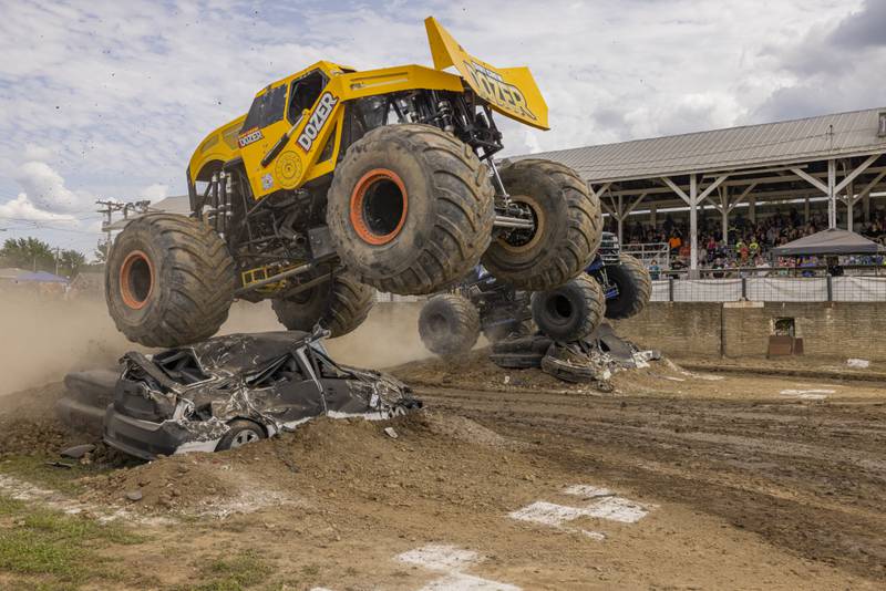 Dirt Crew Dozer leaps to a win Saturday, July 20, 2024, against a rival in the racing portion of the Overdrive Monster Truck Show at Bureau County Fairgrounds in Princeton.