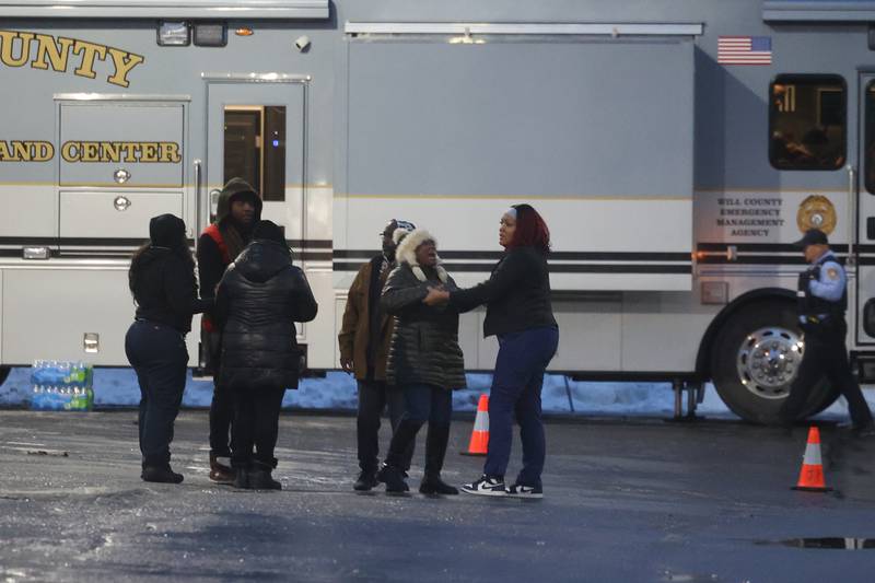 A woman grieves outside the Will County Incident Command Center vehicle in a parking lot along West Acres Road at the scene were multiple people were found dead in two homes on Monday, Jan. 22nd in Joliet.