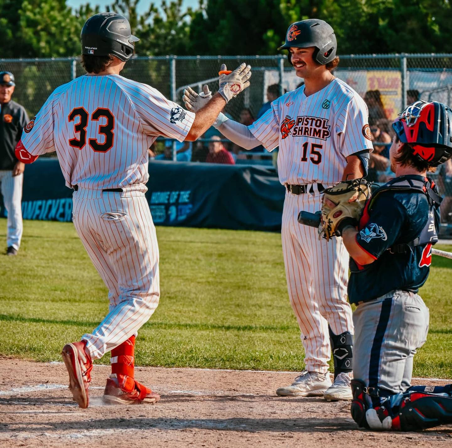 Pambos Nicoloudes (33) high fives Lucas Smith during the Illinois Valley Pistol Shrimp's 9-8 victory over the Chillicothe Paints on Sunday, July 28, 2024 at Schweickert Stadium in Peru.