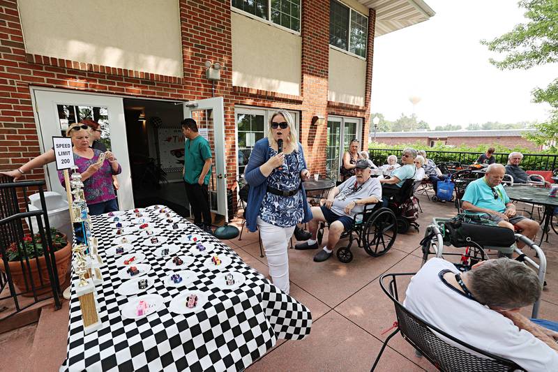 Franklin Grove Assisted Living activity director Vickie Smith starts the award ceremony for the decorated car show Friday, June 23, 2023.