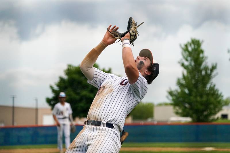 Oswego’s Dylan King (20) plays a pop-up against Oswego East during a baseball game at Oswego High School on Monday, May 13, 2024.