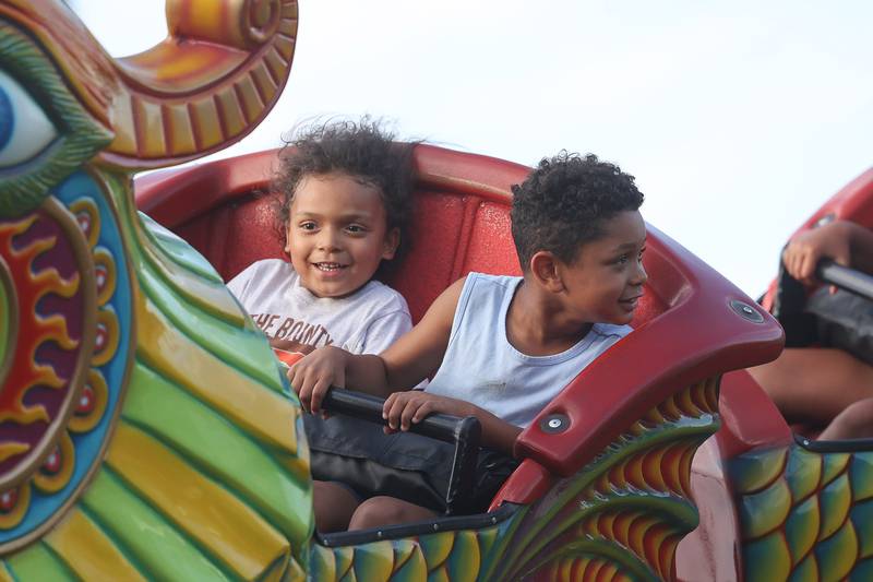 EJ, left, and his brother Xavian ride a roller coaster at the Taste of Joliet on Saturday, June 22, 2024 at Joliet Memorial Stadium.