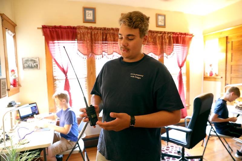 Ben Zielinski, 16, shows one of the hand-held radios he uses. The Zielinski Family of Kaneville; dad Dan, Thatcher, 11, Gabriel, 14, Ben, 16, and Sawyer, 13, are all ham radio operators.