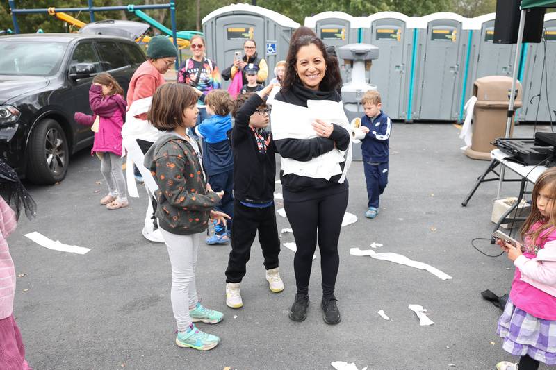 Alyssa Ranta and her brother Trevor wrap their mother Lauren in toilet paper in a Mummy Wrap contest at the Hayride of Horrors on Monday, Oct. 14, 2024 at Dellwood Park in Lockport.