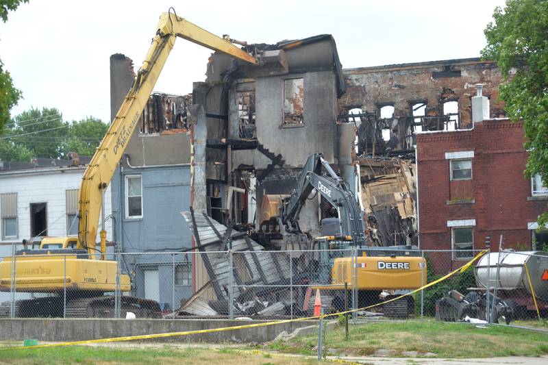 An excavator removes a portion of the back of the building at 406 E. Third St. on Tuesday, July 11, 2023, to allow a search dog to examine debris.