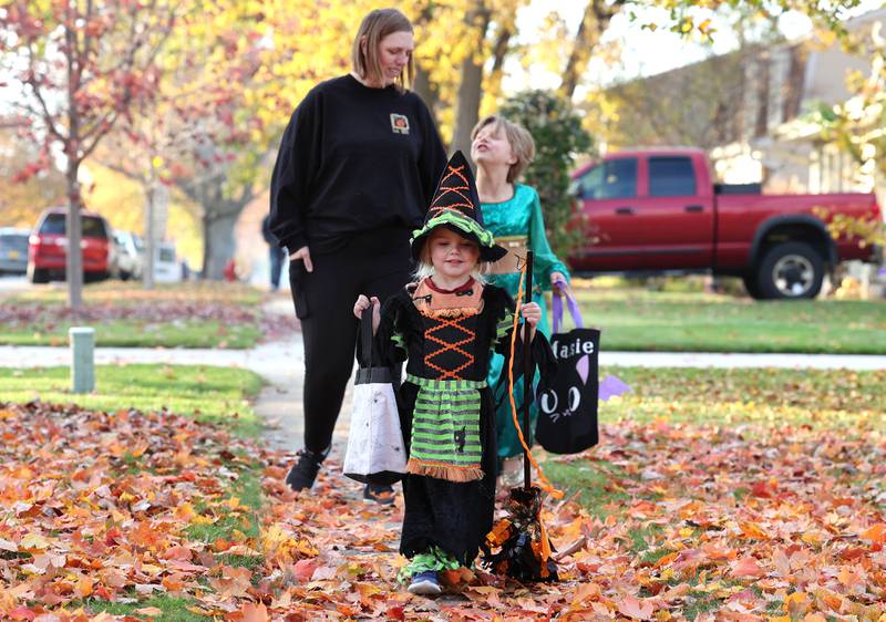 Freya Schnorr, 3, from DeKalb, leads the way for her mom Kat and sister Maise, 7, as they trick-or-treat on Halloween Monday, Oct. 31, 2022, in DeKalb.