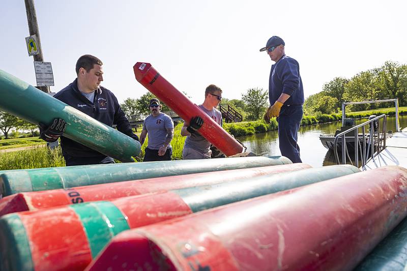 Rock Falls firefighters Brady Franks (left), Brian McPhillips, Brayden Porter and Matt Kobbeman load buoys into a pair of boats Wednesday, May 15, 2024 at the Oppold Marina in Sterling. Rock Falls and Sterling’s fire departments spent the morning placing nearly two dozen buoys in the channel of the Rock River.