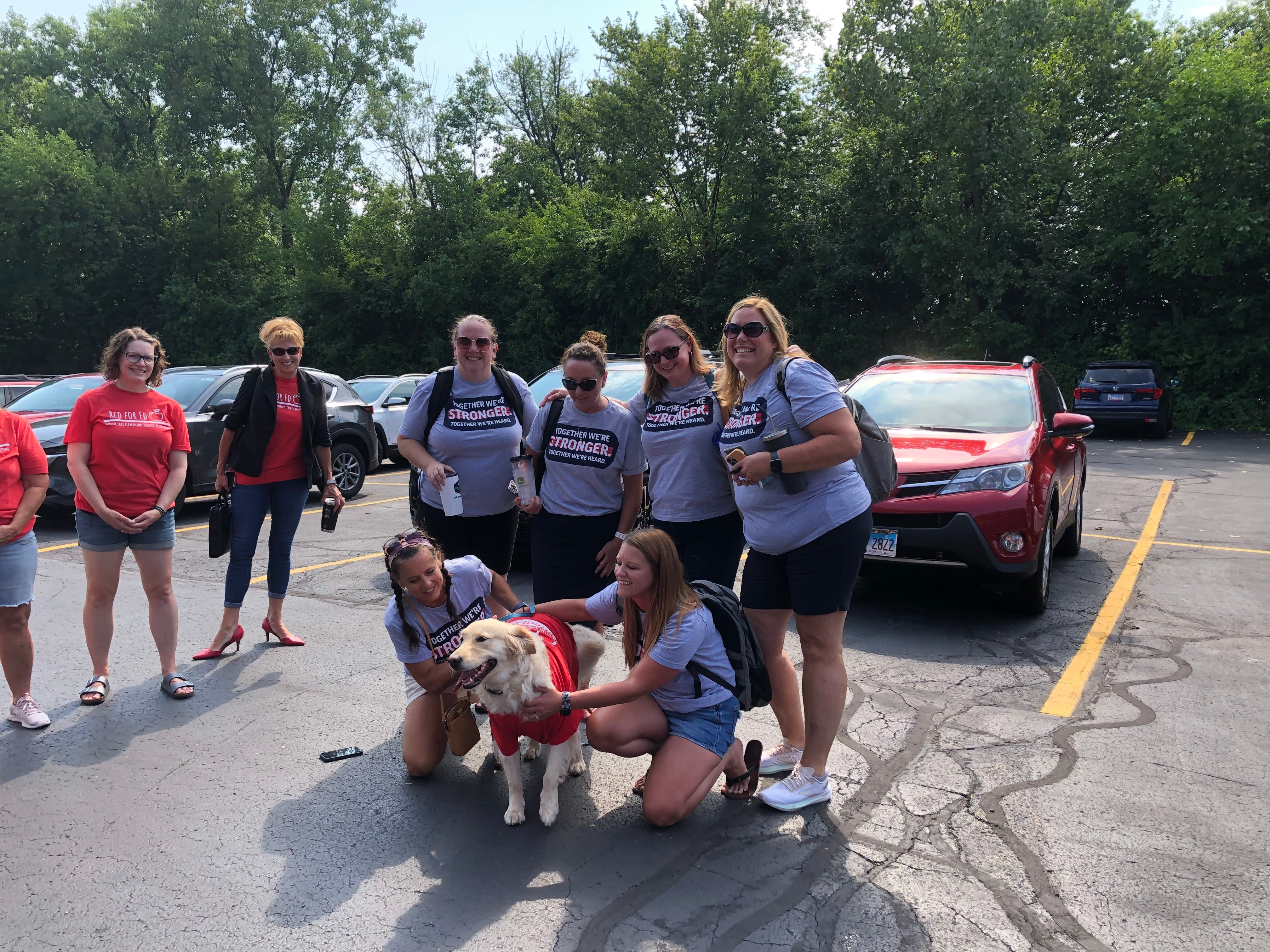 Members of the Crystal Lake Elementary Teachers Union negotiating team pose with a dog, Molly, before they walked into the District 47 office Aug. 5, 2024.