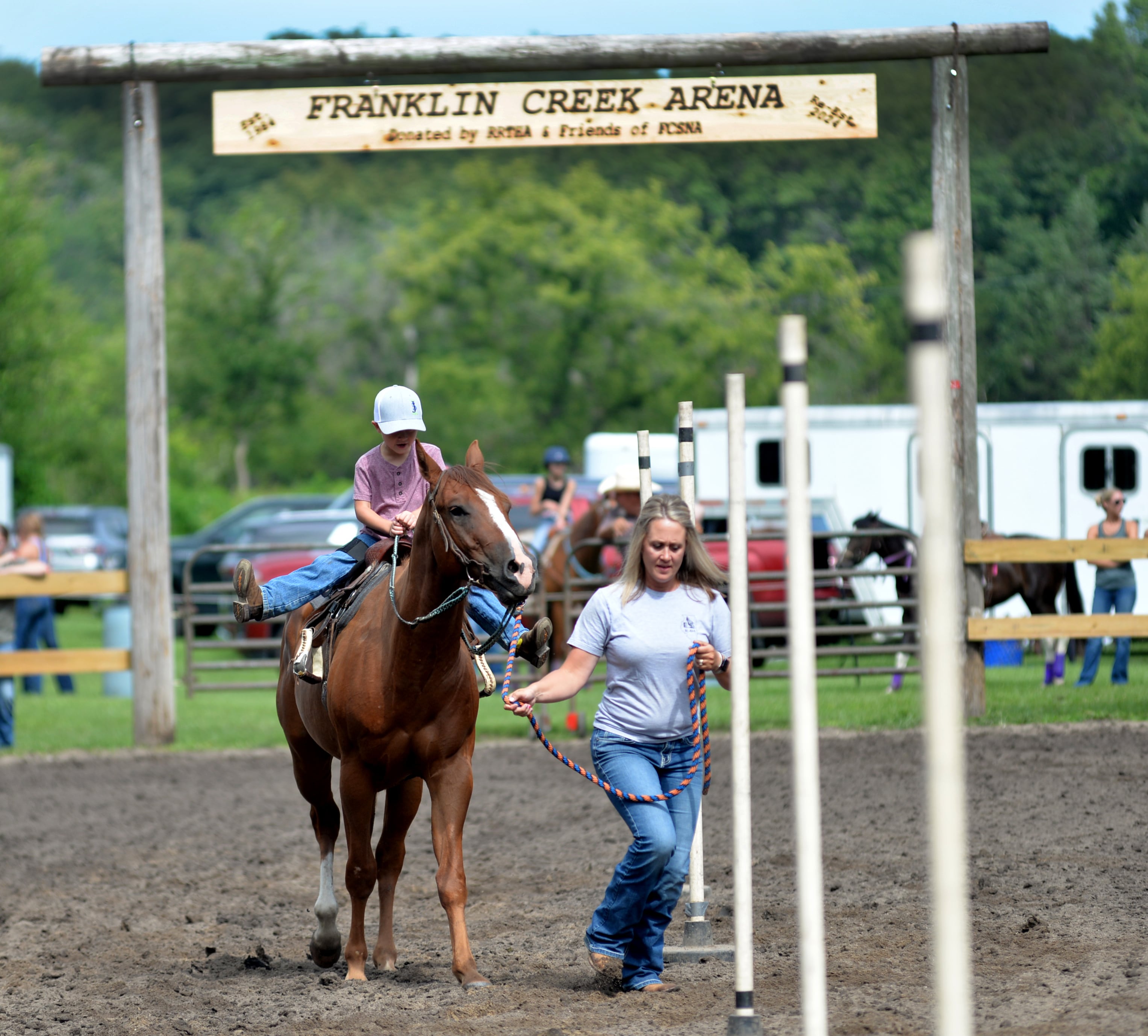 Callie Johnson of Rochelle guides her son, Ty, 5, and his horse Lucky, 3, through the Poles Competition at the Rock River Trail & Horseman Association's Grand Opening Show on Saturday, July 20, 2024.