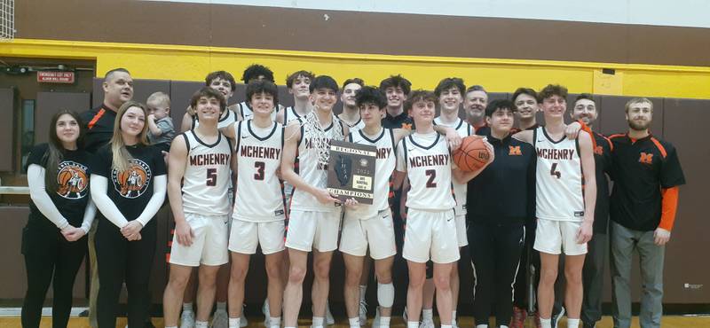 Members of the McHenry boys basketball team pose with their plaque after winning the Class 4A Jacobs Regional title on Friday, Feb. 23, 2024 in Algonquin.