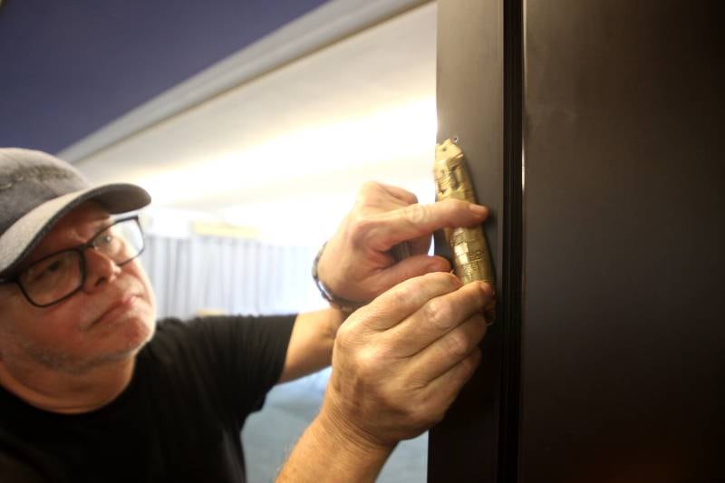 Dale Morton of Bull Valley removes a mezuzot as the McHenry County Jewish Congregation held a deconsecration ceremony at their Ridgefield Road location in preparation for a move to the Tree of Life Unitarian Church in McHenry on Sunday, August 18.