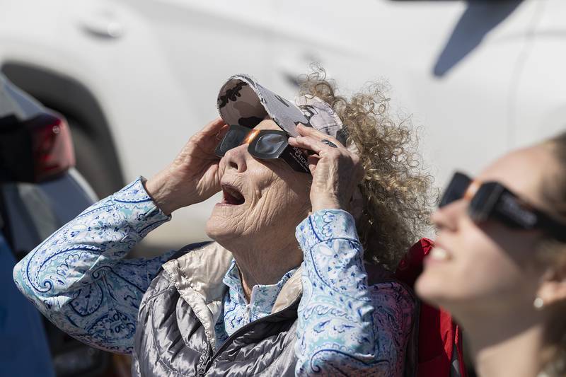 Mary Ristow and granddaughter Hailey Donndelinger of Madison, Wisconsin, check out the emerging eclipse Monday, April 8, 2024. The two drove into Dixon for a better viewing of the celestial phenomenon and found their way to Sauk Valley Community College.