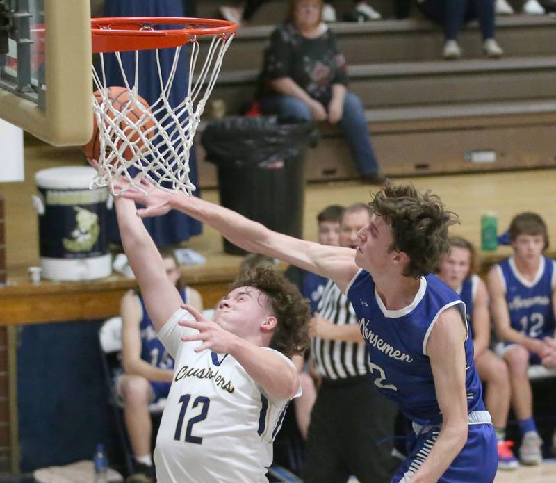 Marquette's Krew Bond drives to the basket as Newark's Cole Reibel draws a foul on Tuesday, Jan. 10, 2023 in Bader Gymnasium at Marquette High School.