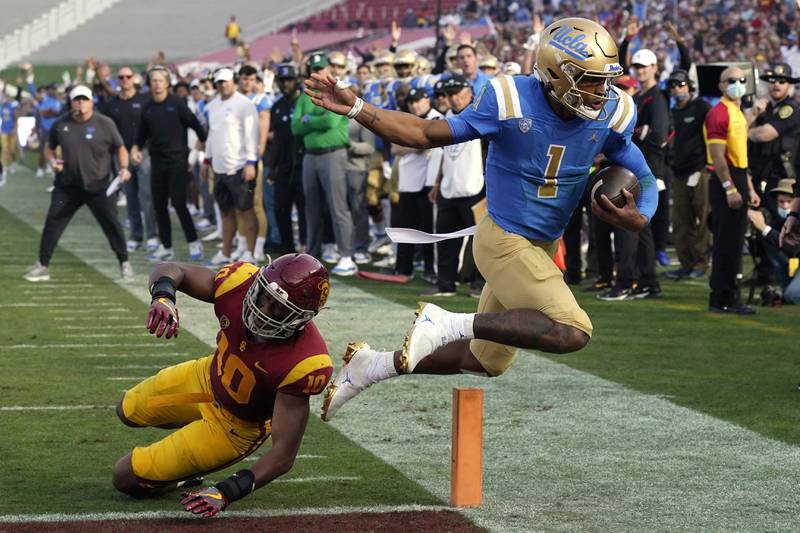 FILE - UCLA quarterback Dorian Thompson-Robinson, right, runs the ball in for a touchdown as Southern California linebacker Ralen Goforth defends during the first half of an NCAA college football game, Saturday, Nov. 20, 2021, in Los Angeles. Thompson-Robinson is back for a fifth season as UCLA's quarterback when many, including coach Chip Kelly, thought he would leave for the NFL. (AP Photo/Mark J. Terrill, File)