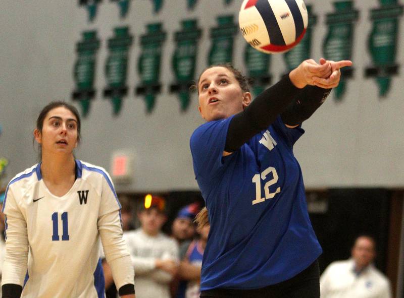 Woodstock’s Maia Garcia Carrasco, right, passes as Ella White watches the action in IHSA Class 3A sectional semifinal volleyball action at Woodstock North Monday.