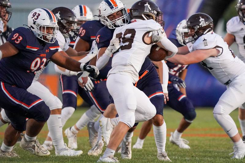 Oswego’s Mikey Claycombe (6) hits Joliet Catholic's Keegan Farnaus (29) in the backfield for a loss during a football game at Oswego High School on Friday, Sep 6, 2024.