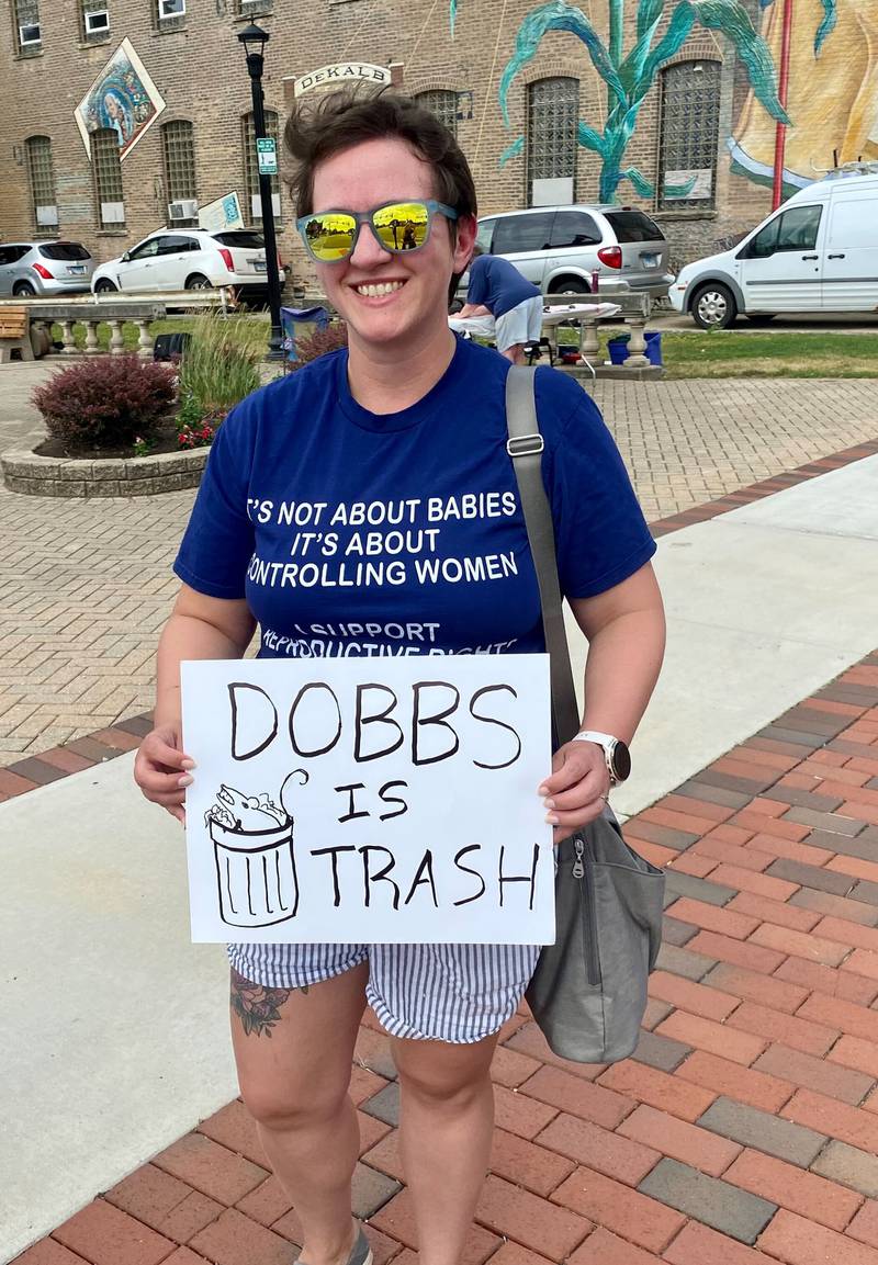 Angie Maloney, 36, of St. Charles formerly of DeKalb, holds a sign that says "Dobbs is trash," during a Rally for Reproductive Rights in downtown DeKalb on Saturday, June 22, 2024. Organizers said the event was held to mark two years since the U.S. Supreme Court overturned federal protections for abortion access, and to help mobilize voters to support pro-abortion candidates ahead of the November election.