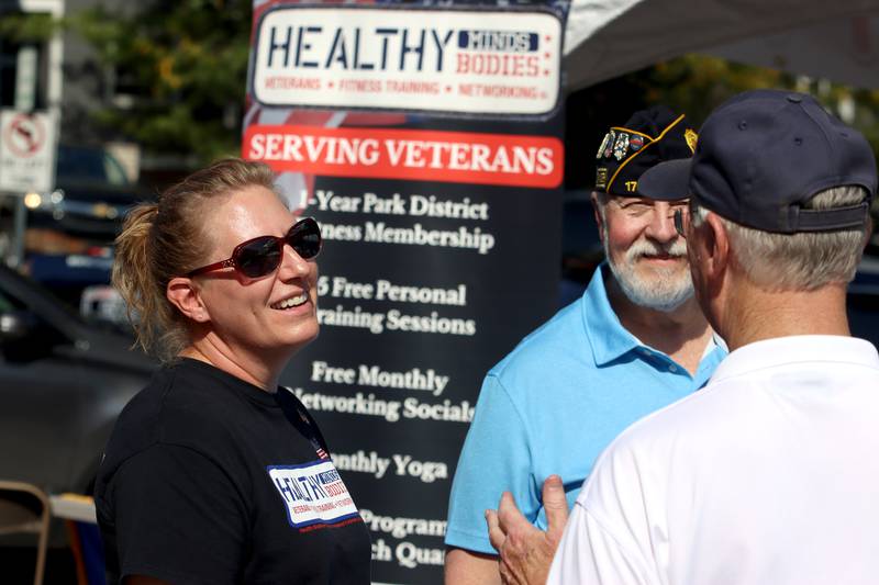 Nicole Eisenrich visits with others at the Crystal Lake American Legion tent during the Johnny Appleseed Festival in Crystal Lake Saturday.