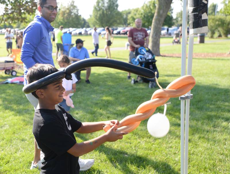 Rita Konanahalli of Elmhurst has fun playing with his baseball hat and ball balloon while attending Park Palooza at Berens Park Saturday Aug 19, 2023.