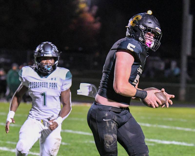 Sycamore Kyle Prebil (5) catches the ball and gains a few yards before being tackled by an Evergreen Park defender in the first quarter Friday Oct. 27, 2023, held at Sycamore High School.