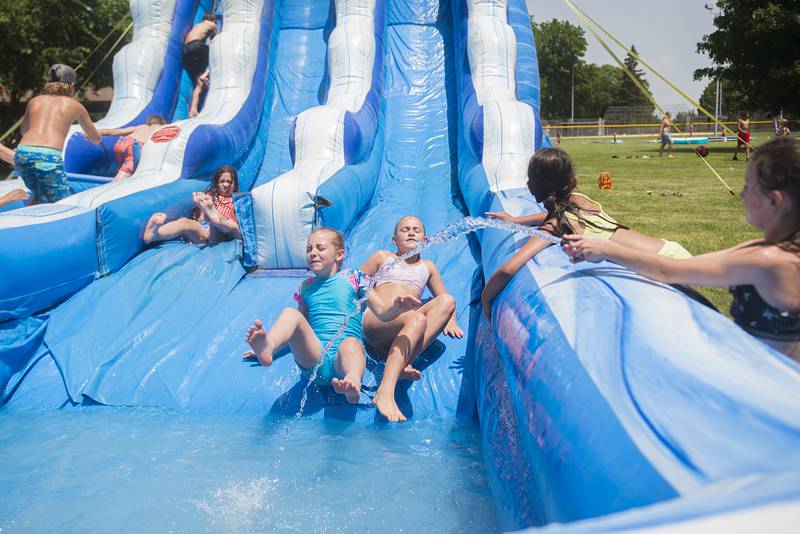 A pair of SPARK campers zip down one of two waterslides on set up at Ballou Park for the day of fun. Friday will be the last day of the camp.