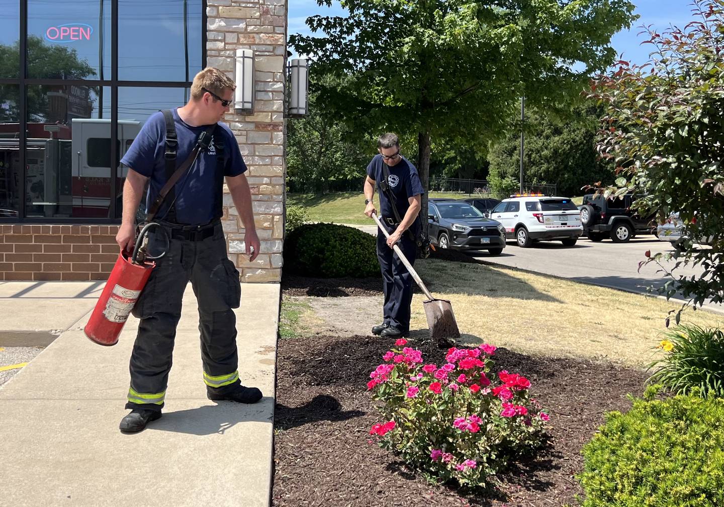 DeKalb Fire lieutenant Jared Thorpe and firefighter Chris Krupa work together to extinguish a small mulch fire that could be seen from DeKalb Avenue on June 9, 2023.