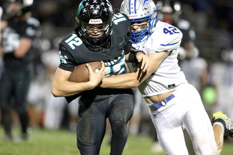 Woodstock North’s Landan Creighton, left, fights off Woodstock’s Zachary Canaday in varsity football at Woodstock North Friday night.