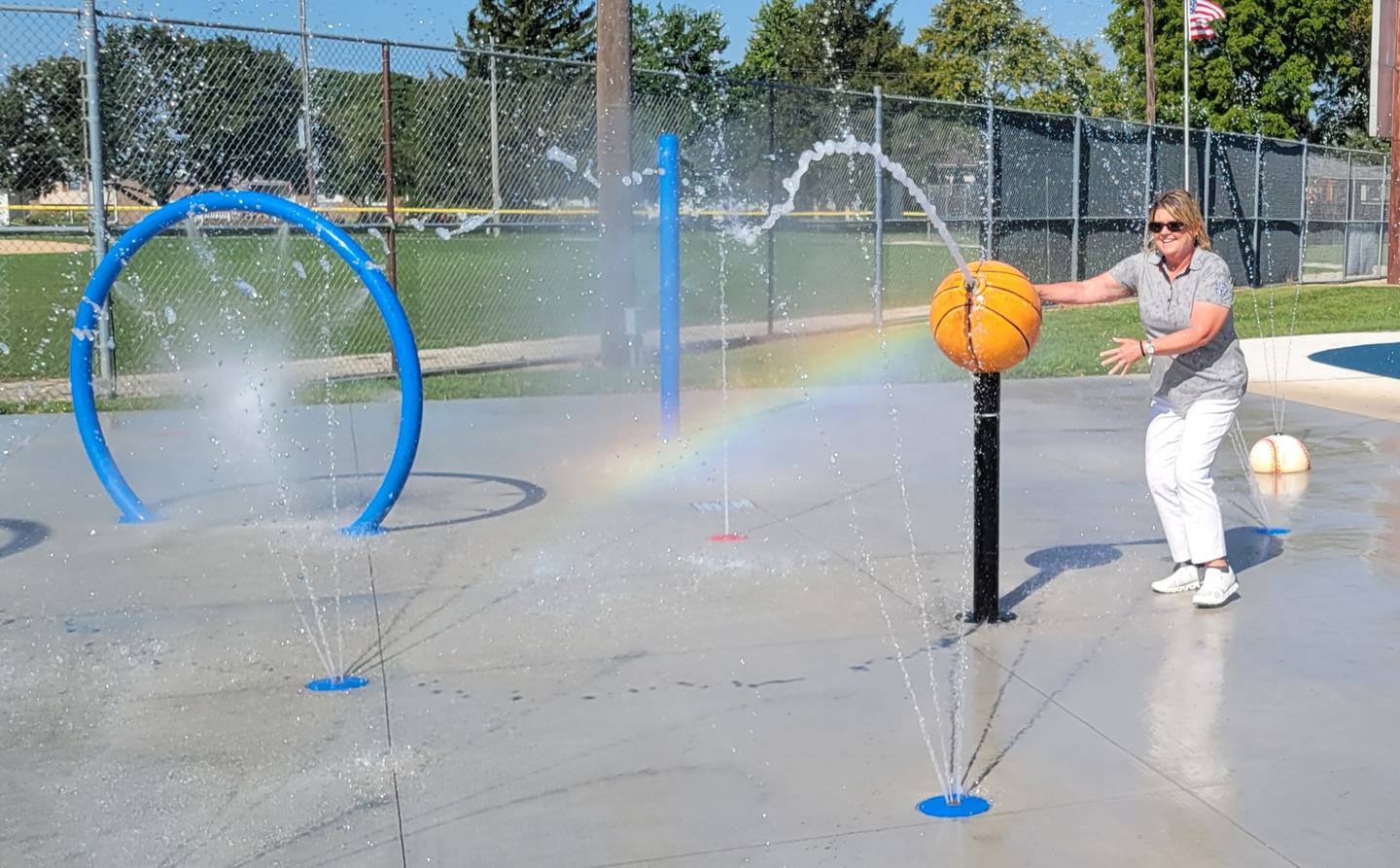 Ottawa Commissioner Marla Pearson playfully checks out her handy work, the new splash pad at Ottawa’s south side Peck Park on Thursday morning.