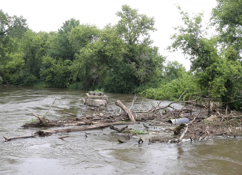 A pile of debris is stacked up in the flooded Kishwaukee River Tuesday, July 16, 2024, near Route 64 west of Sycamore after the severe thunderstorms this week have dumped heavy rains on the area. The storms caused localized damage and flooding throughout DeKalb County.