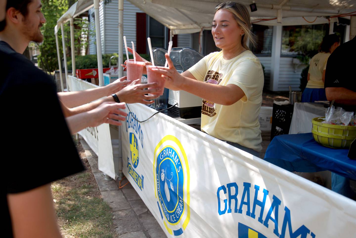 Jordyn Lydon hands out cool treats at the Graham's booth during the first day of Sweden Days in Geneva on Wednesday, June 19, 2024.