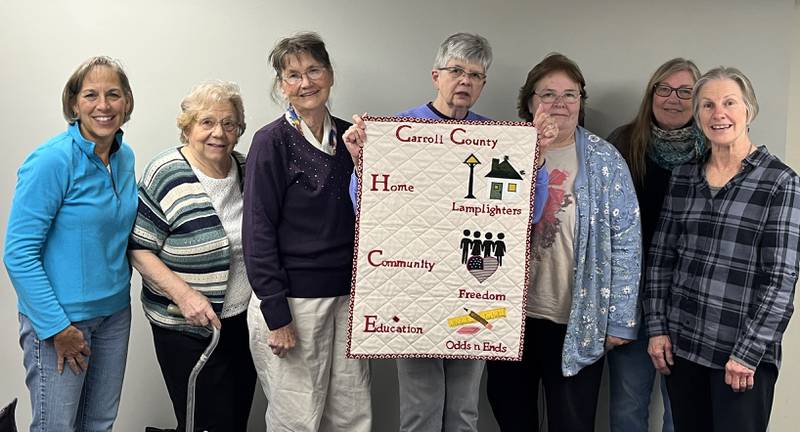 Karen Kromer, Joyce Schubert, Fayellen Sanetra, Charlotte Tarrant, Brenda Gable, Linda Hoelsther and Karen Davis pose with the Carroll County HCE banner.