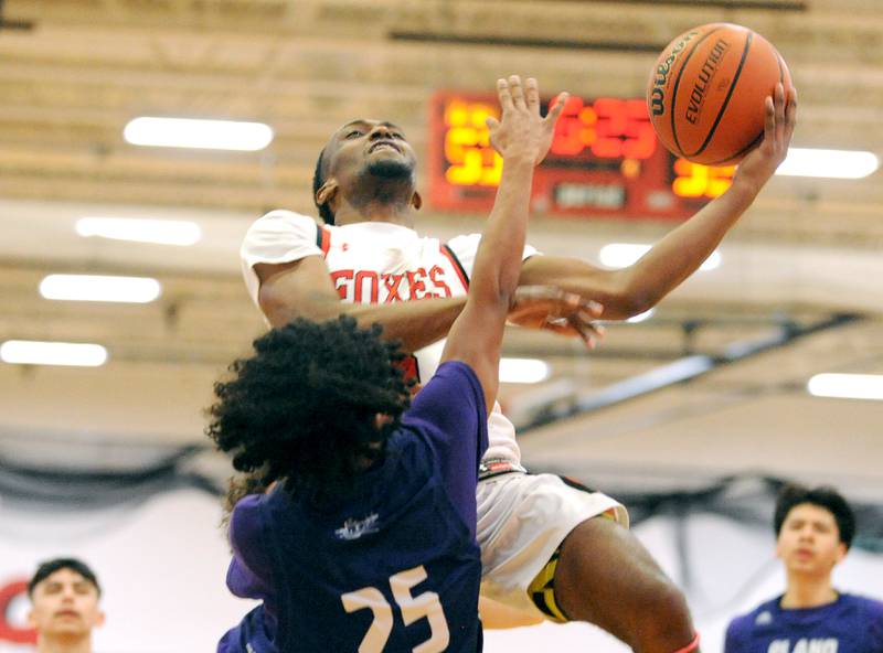 Yorkville's Dayvion Johnson goes up against Plano defender Amari Bryant (25) for the 2-points and the foul during a varsity basketball game at Yorkville High School on Tuesday, Dec. 19, 2023.