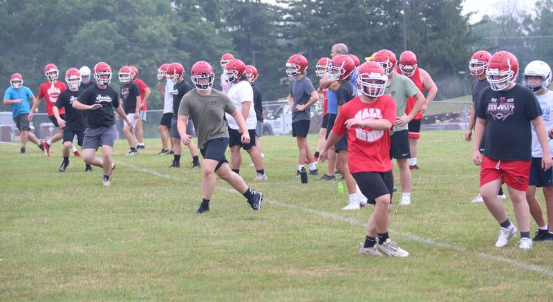 Hall football players warm up before practice on Tuesday, July 9, 2024 at Hall High School.