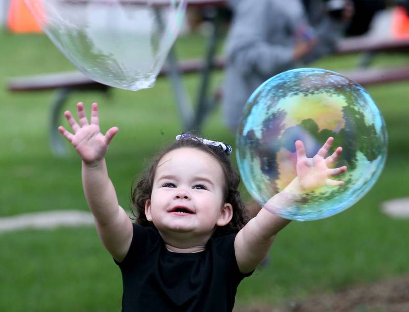 Brynn Nelson chases after a giant bubble during the National Night event on Tuesday, Aug. 6, 2024 at Zearing Park in Princeton.